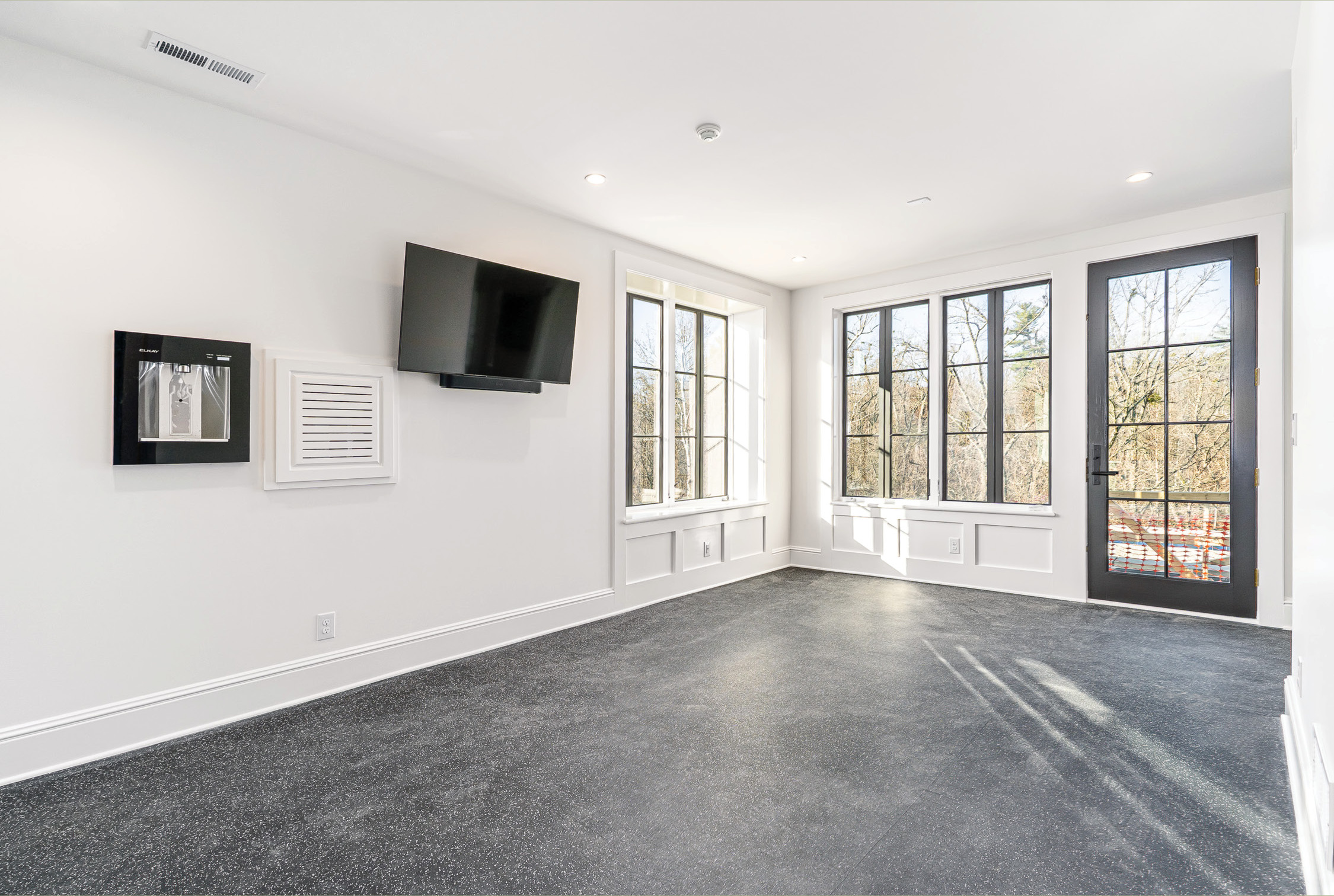 Bonus room with windows on two walls and a wall-mounted television